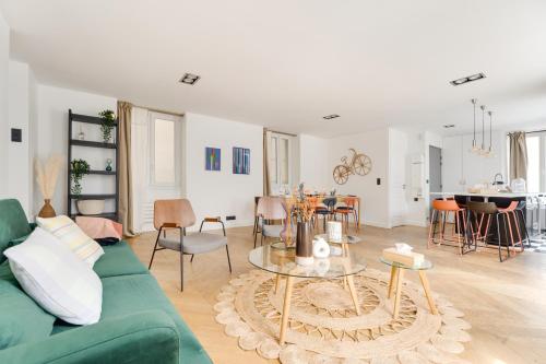 un salon avec un canapé vert et une table dans l'établissement PorteMaillot & La Défense 4 Bedroom 10 people, à Neuilly-sur-Seine