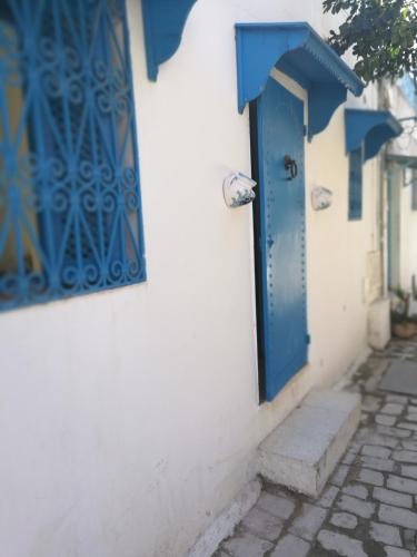 a blue door on the side of a building at Maison Ghemrini in Sidi Bou Saïd