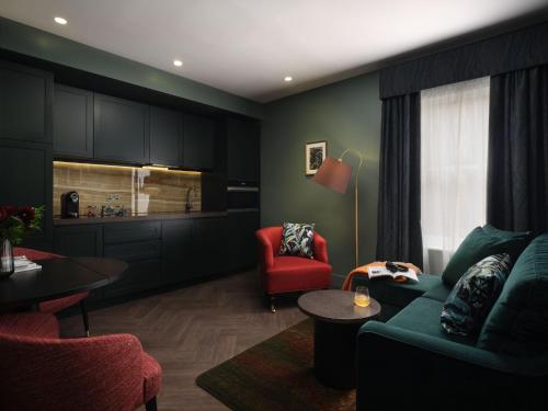 a living room with a couch and a red chair at The Other House South Kensington in London