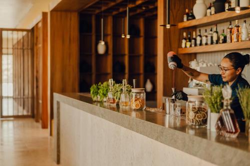 a woman preparing a drink at a bar at Nobu Hotel Los Cabos in Cabo San Lucas
