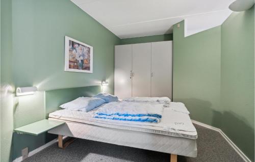 a bed in a room with green walls at Fan Bad, Lejl, 11 in Fanø