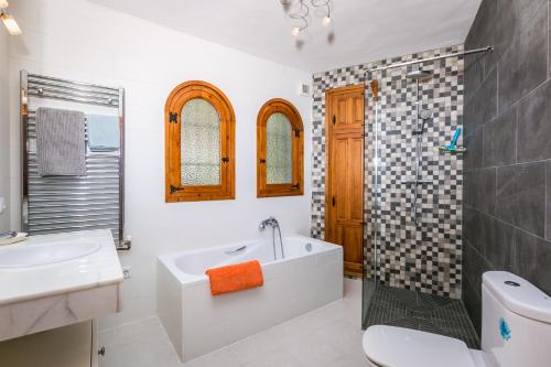 a bathroom with a tub and a toilet and a sink at Casa Toscana in Jávea