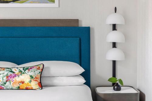 a bedroom with a bed with a blue headboard and two lamps at Kimpton Hotel Monaco Salt Lake City, an IHG Hotel in Salt Lake City