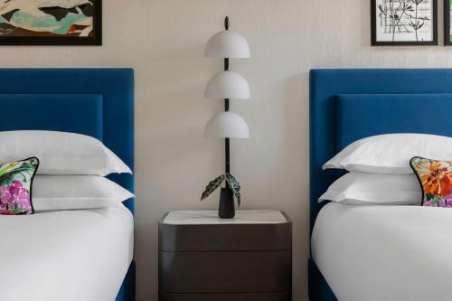 a bedroom with two beds with blue and white pillows at Kimpton Hotel Monaco Salt Lake City by IHG in Salt Lake City