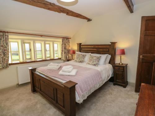 a bedroom with a large bed with two towels on it at The Farmhouse in Keighley