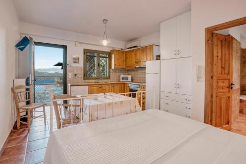 a kitchen with a white bed and a table at Diodati Villas in Nikiana