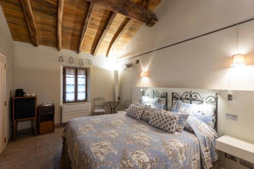 a bedroom with a bed with a blue comforter at Antica Corte Pallavicina Relais in Polesine Parmense