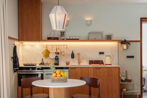 a kitchen with a table with a bowl of fruit on it at Botanica Living Magnolia Apt in Quinta Grande