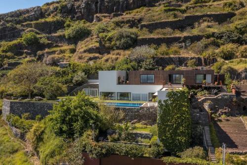 a house on a hill with a swimming pool at Botanica Living Magnolia Apt in Quinta Grande