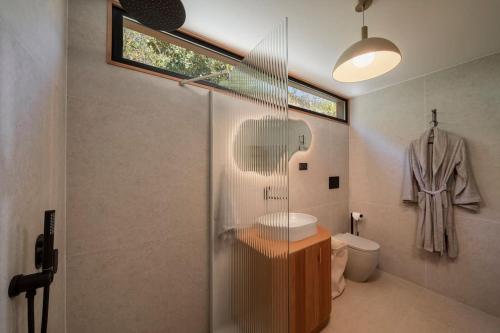 ein Bad mit einer Dusche, einem Waschbecken und einem WC in der Unterkunft Botanica Living Magnolia Apt in Quinta Grande