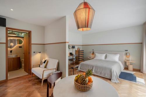 Un dormitorio con una cama y una mesa con un bol de fruta en Botanica Living Magnolia Apt, en Quinta Grande