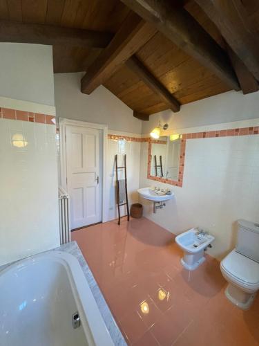 een badkamer met een bad, een toilet en een wastafel bij VILLA FELICE_UNESCO ALPS AREA in Verzuolo