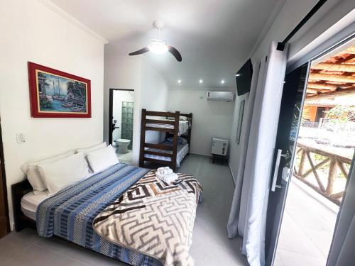 a bedroom with a bed and a view of a balcony at Pousada Sobre As Ondas de Picinguaba in Picinguaba