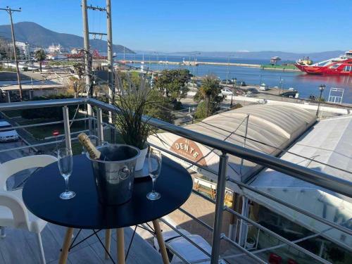 una mesa con copas de vino y una maceta en el balcón en Dukas Apartment, en Limenas
