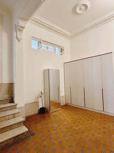 una stanza vuota con armadi bianchi e una scala di Rococo Apart a Montevideo