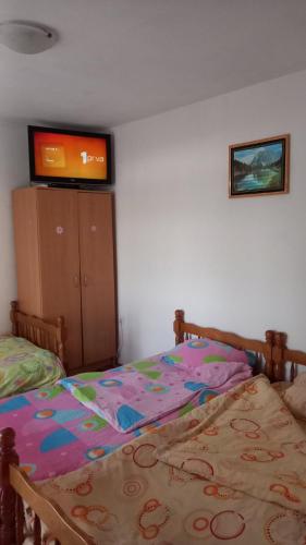 a bedroom with a bed and a tv on the wall at Maja Apartman in Igalo