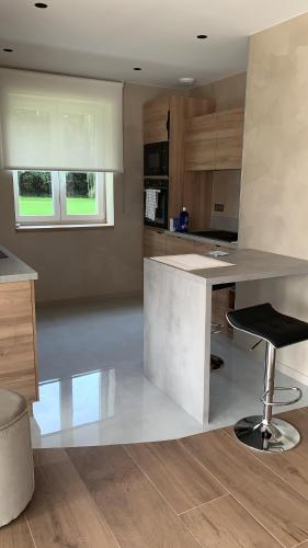 a kitchen with a white counter and a stool at LES GITES DE LA KARLSMUHLE in Haguenau