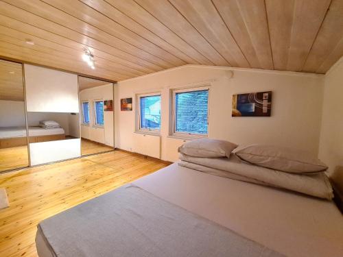 DT Serene Villa - Lillestrøm في ليلستروم: سريرين في غرفة ذات سقف خشبي