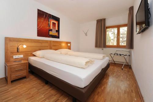 1 dormitorio con 2 camas y TV en la pared en Kleiner Turm 1, en Schruns