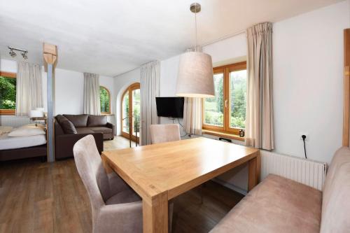 uma sala de estar com uma mesa de madeira e cadeiras em Kleiner Turm 03 em Tschagguns