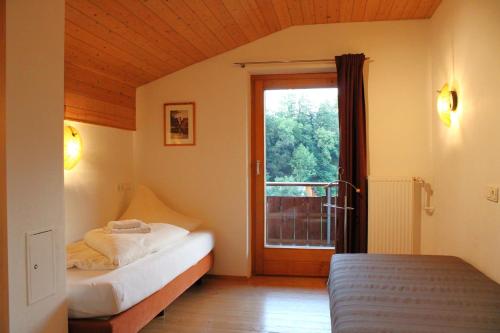 ein Schlafzimmer mit 2 Betten und eine Tür mit einem Fenster in der Unterkunft Kleiner Turm 4 in Tschagguns