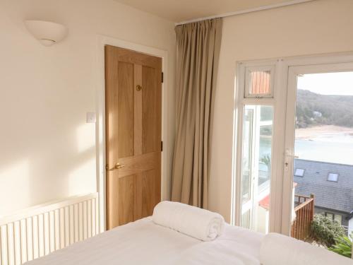 a bedroom with a bed and a large window at The Bolthole at Bay View House in Salcombe