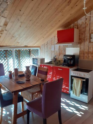 cocina con mesa de madera y armarios rojos en Gîte de la Ouedolle, en Sengouagnet