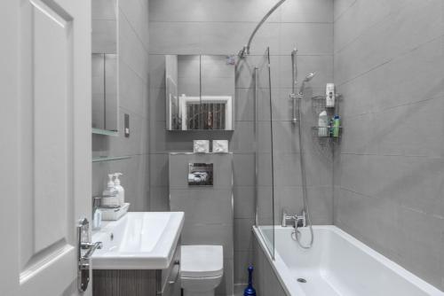 uma casa de banho com um chuveiro, um lavatório e um WC. em Quirky, Vintage 2 bed flat em Londres