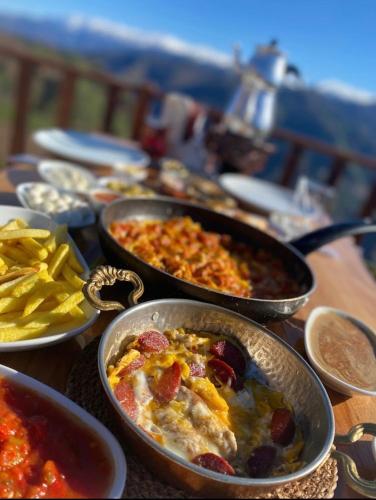 a table topped with pans of food and chips at LİVORA DAĞ EVLERİ in Çamlıhemşin