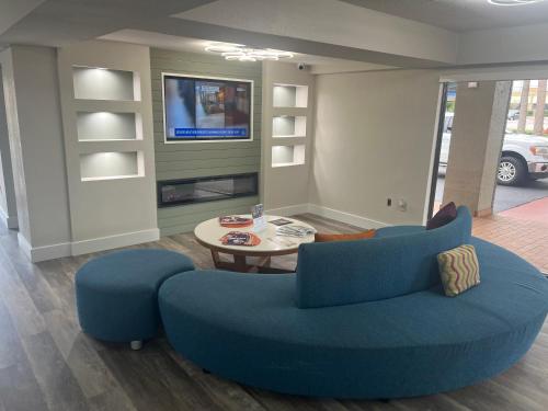 a living room with a blue couch and a table at Quality Inn & Suites Orlando East - UCF Area in Orlando