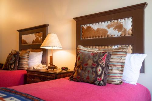 a bedroom with two beds and a lamp and a phone at Sheridan Inn - Best Western Signature Collection in Sheridan