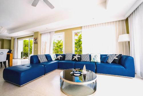 um sofá azul numa sala de estar com uma mesa em Luxury Villa Iberosta - 4BDR, Private Beach, Pool & Jacuzzi em Punta Cana