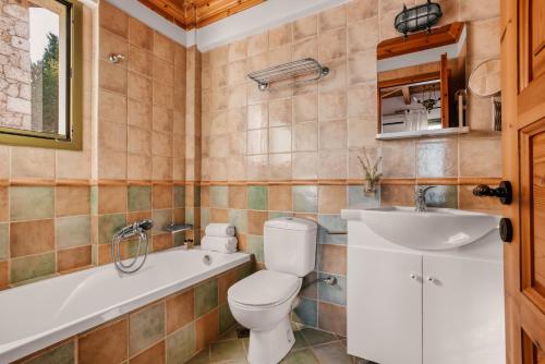 La salle de bains est pourvue de toilettes, d'une baignoire et d'un lavabo. dans l'établissement Diodati Villas, à Nikiana