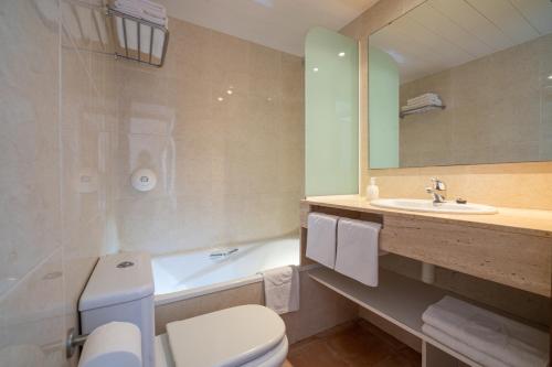 uma casa de banho com um WC, um lavatório e uma banheira em Albamar Apartaments em Lloret de Mar