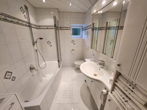 a white bathroom with a shower and a sink at Ferienwohnung Söllner in Kitzbühel