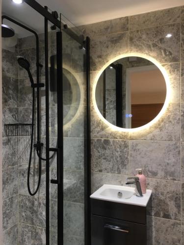 a bathroom with a sink and a shower with a mirror at Fareham Heights in Fareham