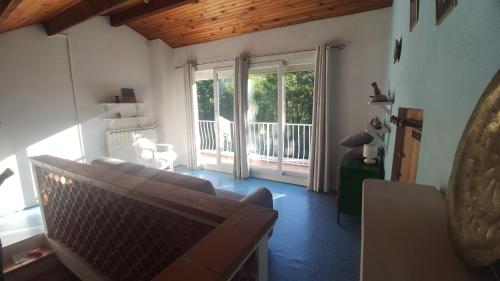 un salon avec un canapé et une porte coulissante en verre dans l'établissement La clairière, à Pierrelongue