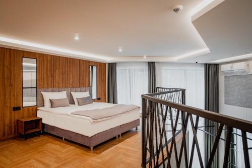 Bursztynowe Resort&SPA Stegna في ستيغنا: غرفة نوم بسرير كبير ودرج