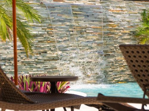 a fountain in front of a swimming pool at Hotel Velas do Engenho in Ilhabela
