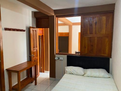 1 dormitorio pequeño con 1 cama y armario de madera en Casa Foranea, en Concepción