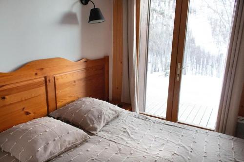 1 dormitorio con cama y ventana grande en Rez de chalet, Sauna extérieur, Wifi, 4-6 pers, 50m2, en Isola 2000