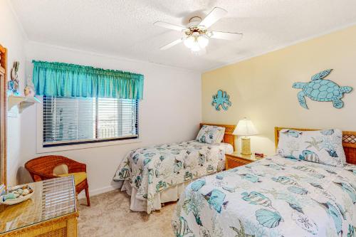 1 dormitorio con 2 camas y ventilador de techo en Island Beach & Racquet Club A309, en Atlantic Beach