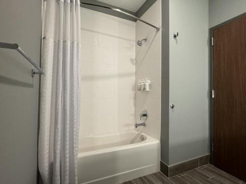 a bathroom with a white tub and a shower curtain at La Quinta Inn & Suites by Wyndham Mount Laurel Moorestown in Mount Laurel