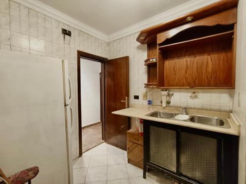 a kitchen with a sink and a refrigerator at Luxury 2 bedroom apartment at the heart of modern Cairo directly on Salah Salem main street in Cairo