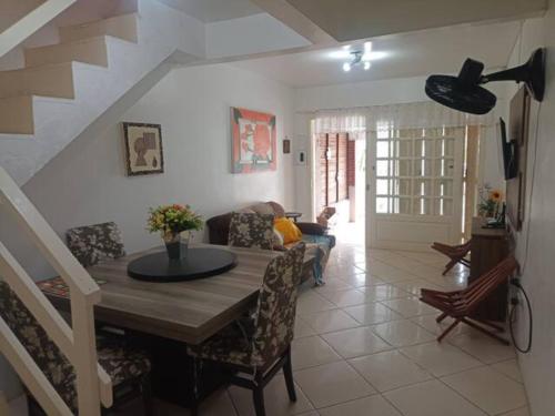 uma sala de estar com uma mesa e um sofá em Lindo Duplex à 50 metros da praia em Imbé