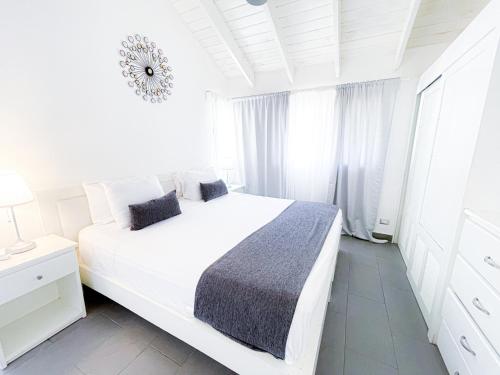 a white bedroom with a large white bed and a window at Skyline Ocean Breeze HOTEL with VIEW Los Corales BBQ WiFi Beach CLUB & SPA in Punta Cana