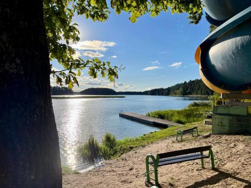 a bench sitting next to a body of water at Wigierska Osada 2 in Danowskie