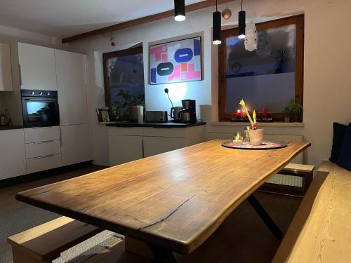 a kitchen with a wooden table in a room at Haus Alberto - Haus mit 2 Ferienwohnungen in Ötztal-Bahnhof