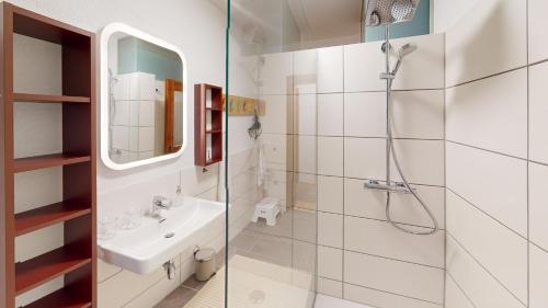 y baño blanco con lavabo y ducha. en Haus Alberto - Haus mit 2 Ferienwohnungen, en Ötztal-Bahnhof