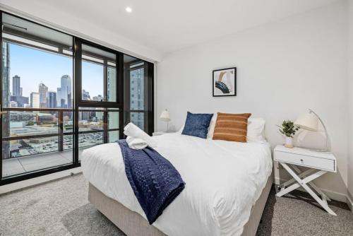 a bedroom with a bed and a large window at New Stature Southbank Luxury in Melbourne